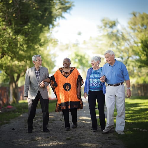 Home 3 Four Older Adults Walk Together Outside